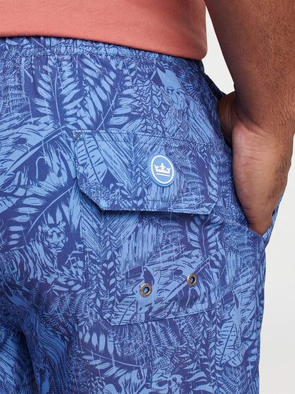 Close-up view of a person's hip wearing blue Peter Millar Tropicrazy Swim Trunk in Atlantic Blue with a hand in the pocket.