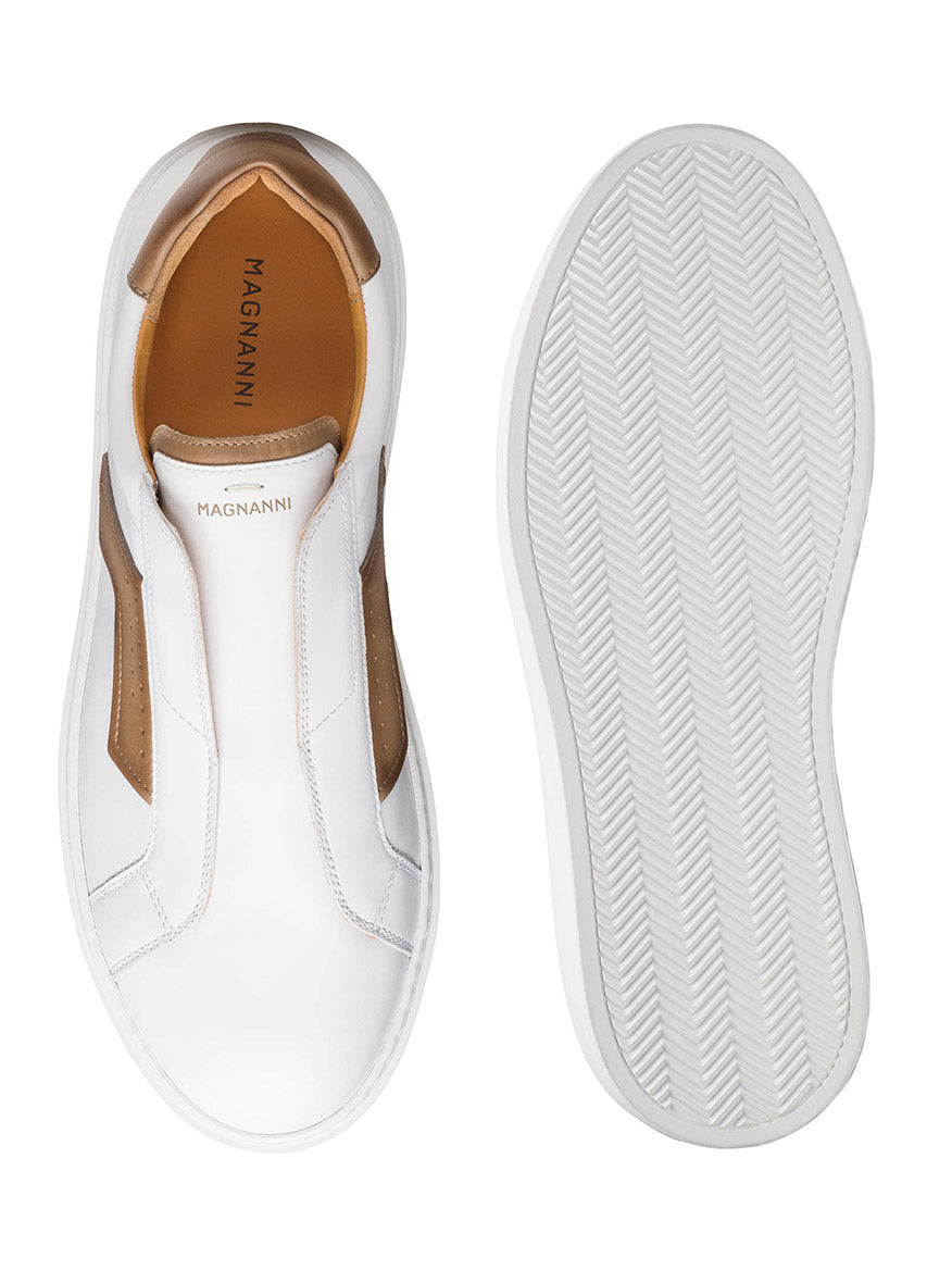 The Magnanni Phoenix Slip in White/Taupe are unique slip-on sneakers with wing-inspired leather accents and a hidden elastic gore system for a seamless fit. From top to sole, they feature smooth leather with minimal stitching, and "Magnanni" is elegantly visible inside and out.