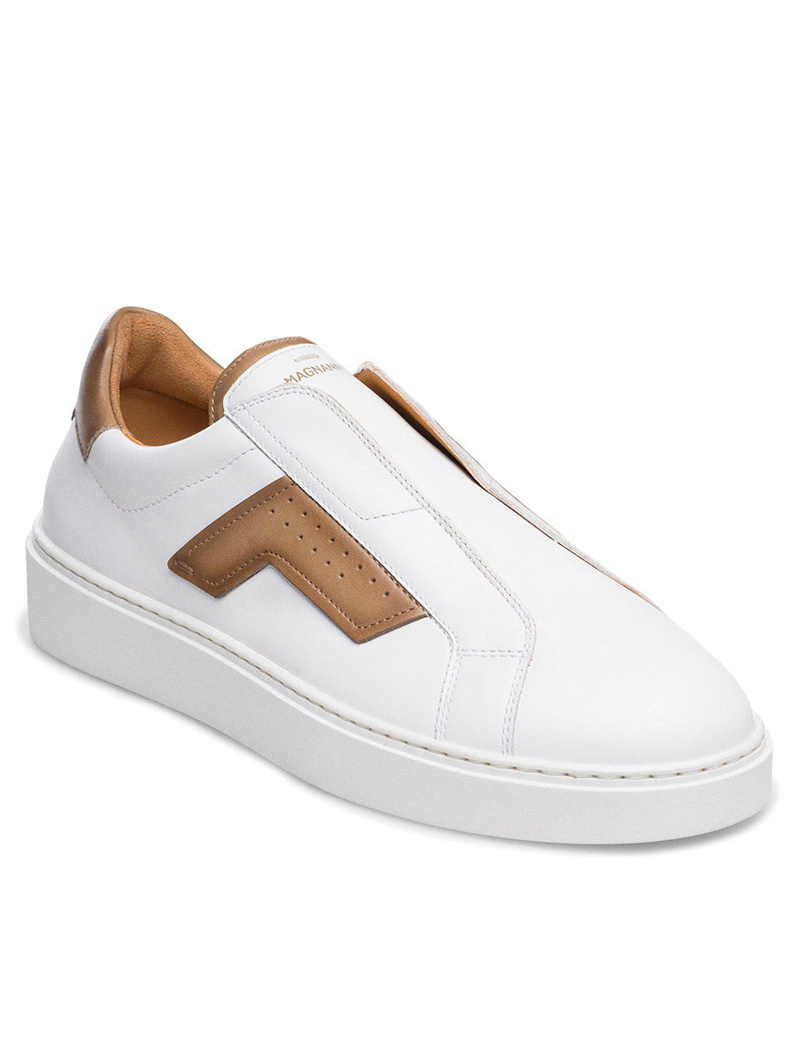 The Magnanni Phoenix Slip in White/Taupe is a unique slip-on sneaker with a white leather finish, featuring a hidden elastic gore system for easy wear. Tan accents and wing-inspired detailing enhance the thick white sole, while a brown zigzag design adds flair to this lace-less masterpiece.