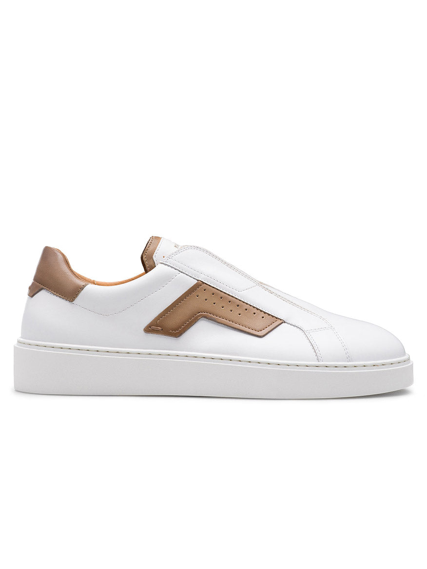 The Magnanni Phoenix Slip in White/Taupe is a distinctive slip-on sneaker made with white leather and taupe accents resembling wings. It features a raised sole, zigzag side design, heel pull tab, and hidden elastic gore for easy wear and comfort.
