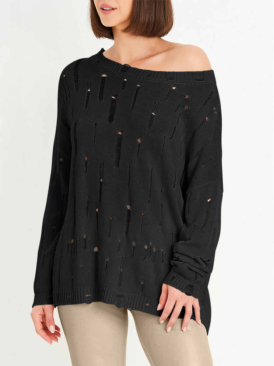 Woman wearing the Planet by Lauren G Undone Boatneck Sweater in Black with beige pants, standing against a plain light background.