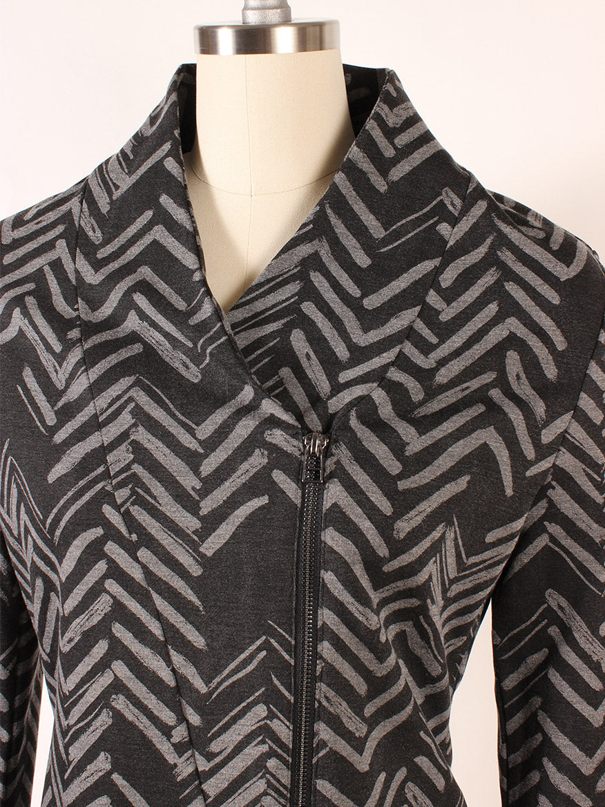 Close-up of a Porto Alba Ponte Jacket in Canterbury Heather Grey with black geometric patterns displayed on a mannequin, featuring an off-center zip placket.