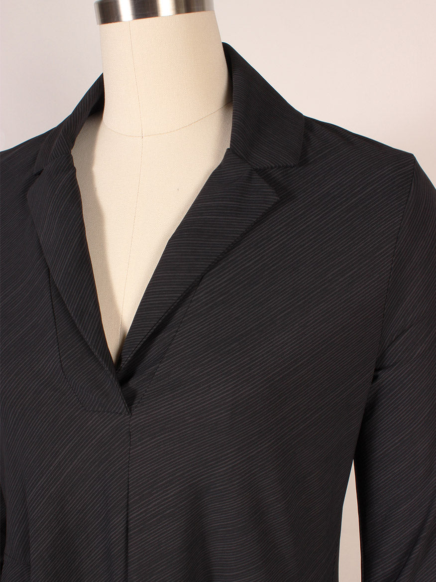 A close-up of the Porto Flavia Dress in Smoke Reggio on a dress form, highlighting its neckline, split lapel collar, and upper sleeves.