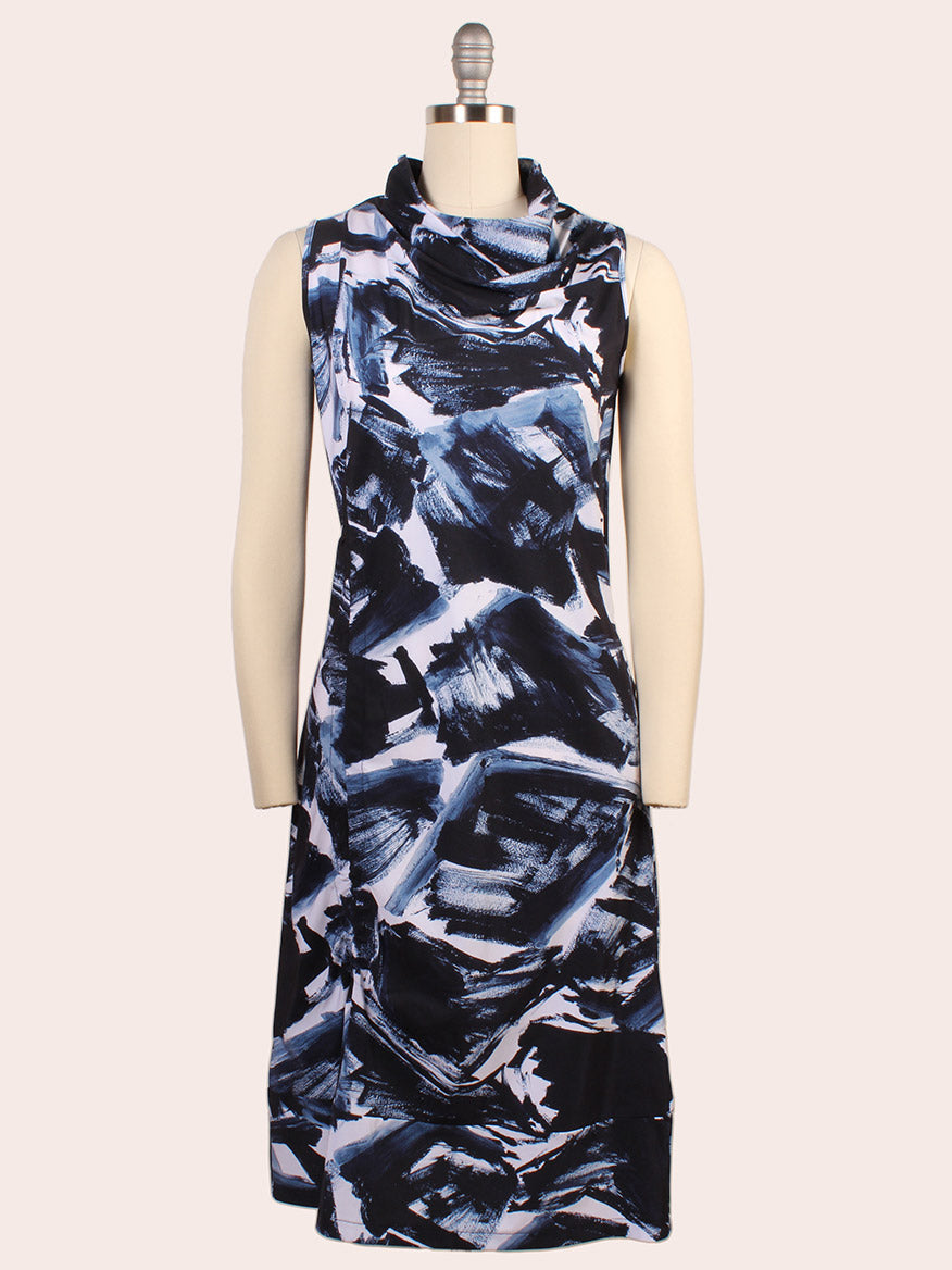 The Porto Indira Ruched Dress in Shadow Shodo is a sleeveless, knee-length dress with a cowl neckline and abstract blue, black, and white brushstroke pattern, made in Italy for a refined style.