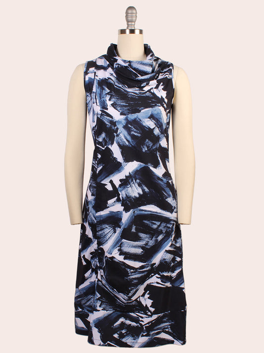 The Porto Indira Ruched Dress in Shadow Shodo is a sleeveless, knee-length dress with a cowl neckline and abstract blue, black, and white brushstroke pattern, made in Italy for a refined style.