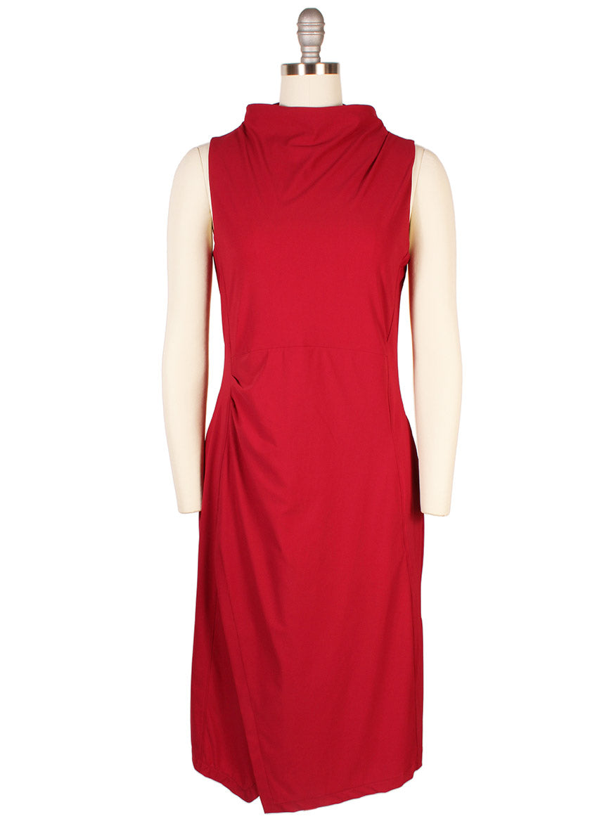 The Porto Nina Dress in Garnet, crafted in Italy, features a draped neckline and subtle side ruching on a knee-length silhouette, elegantly shown on a mannequin.