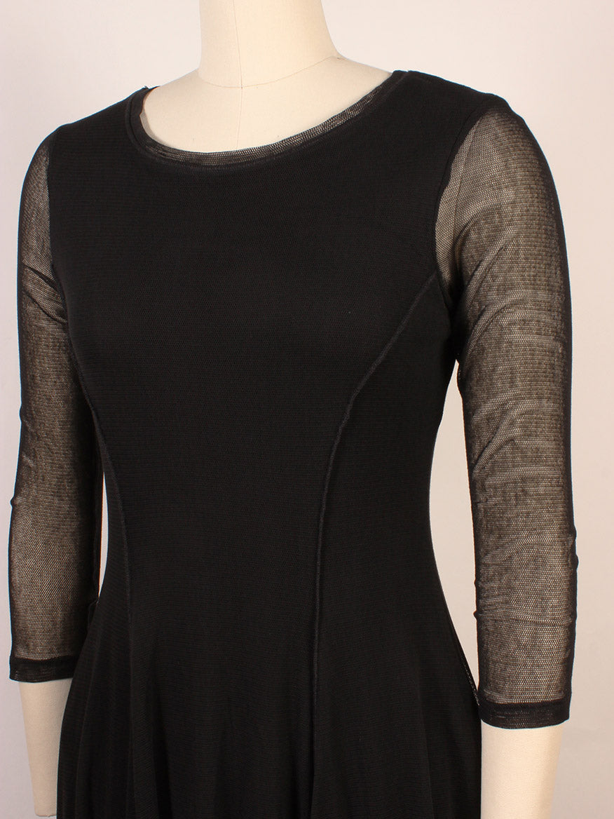 A mannequin dressed in the Porto Pendulum Dress in Black, featuring a fit-and-flare silhouette, sheer three-quarter sleeves, and a round neckline.