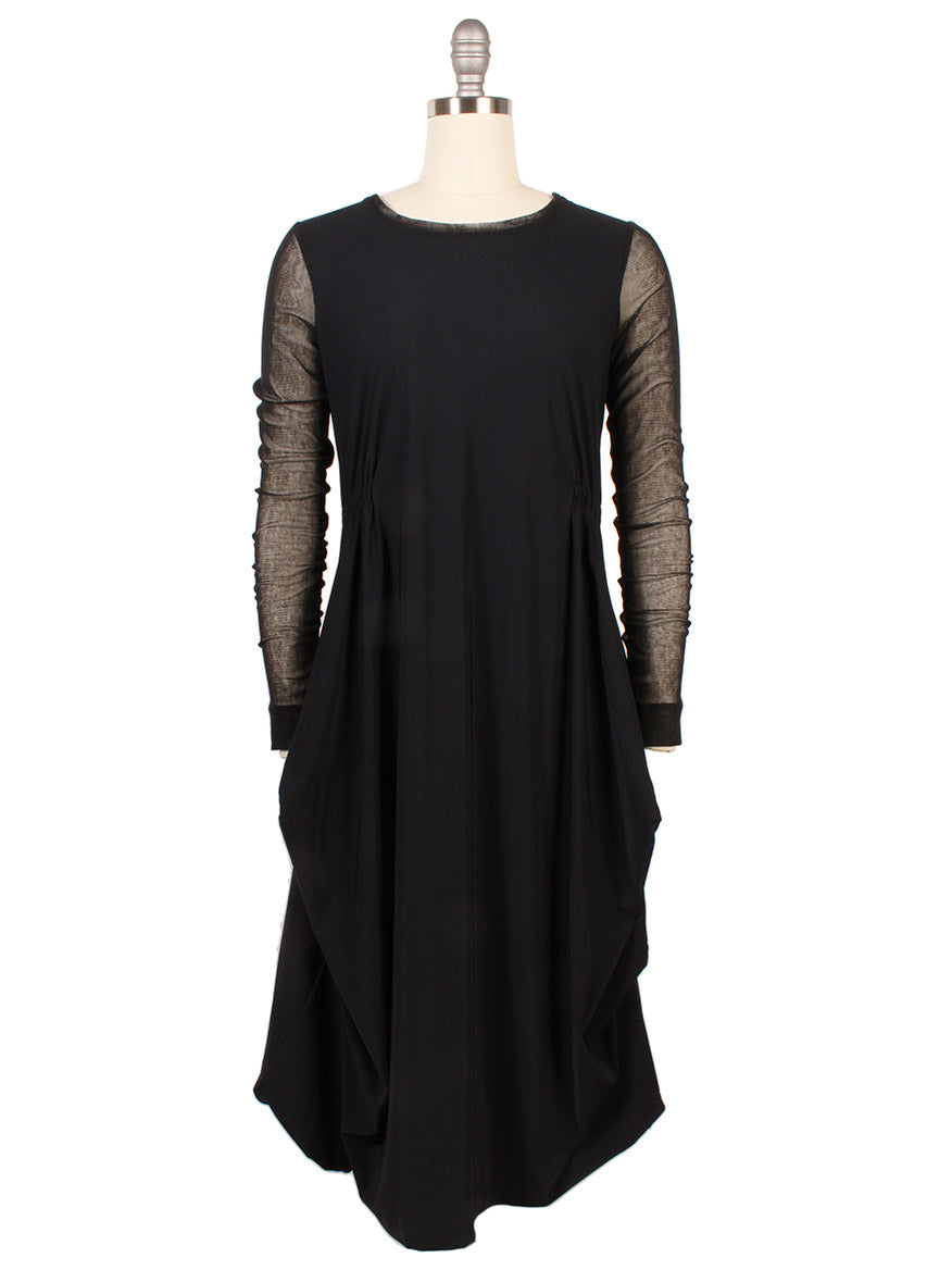 The Porto Venetian Dress in Black features mesh long sleeves, a round neckline, and draped side panels, shown on a dress form.
