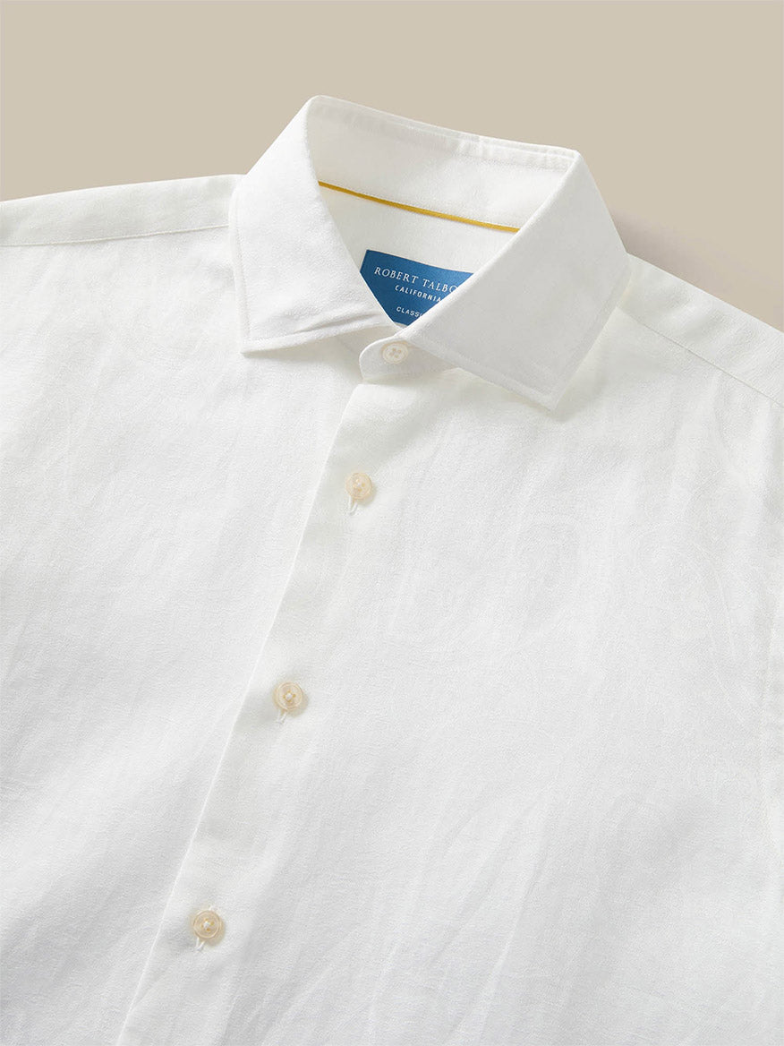 The Robert Talbott Reynolds Paisley Jacquard Dress Shirt in White features a spread collar, beige buttons, and a blue inner neck label, crafted from fine Italian fabric with tailored construction and shown against a neutral background.