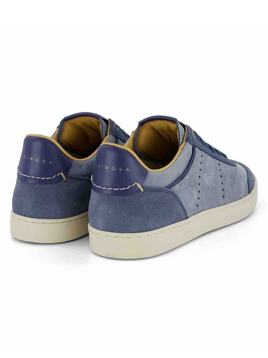 The Rubirosa JUDY Sneakers in Blue Suede feature off-white soles and tan lining, handmade in Italy. Shown from back and side angles, they're a stylish pick for sustainable fashion enthusiasts.