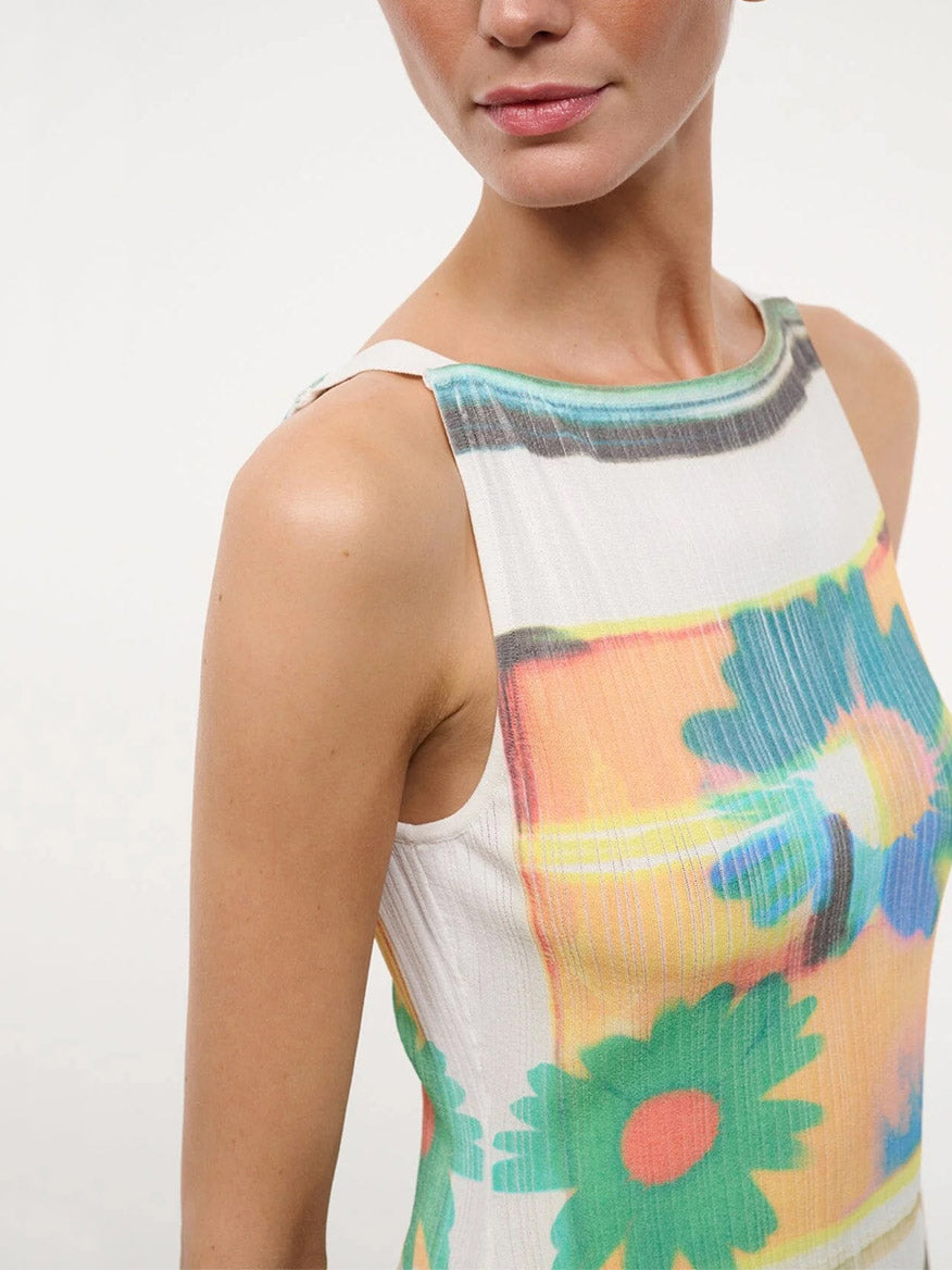 A woman wears the STAUD Bryn Top in Superbloom Scarf, featuring a corset-style design with a colorful, abstract floral pattern on a white background.