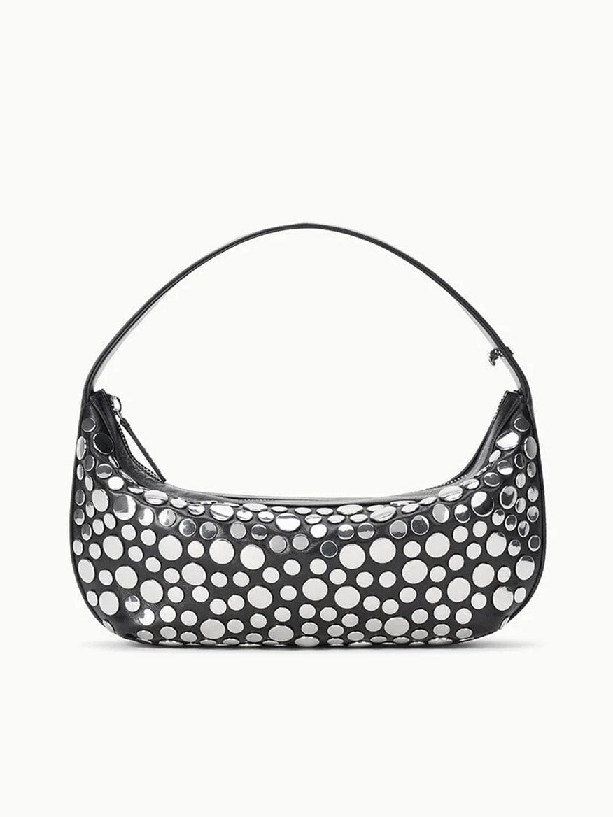 The STAUD Demy Shoulder Bag in Rivets is a black nappa leather handbag with a single strap, adorned with large, irregular white polka dots for a playful touch.
