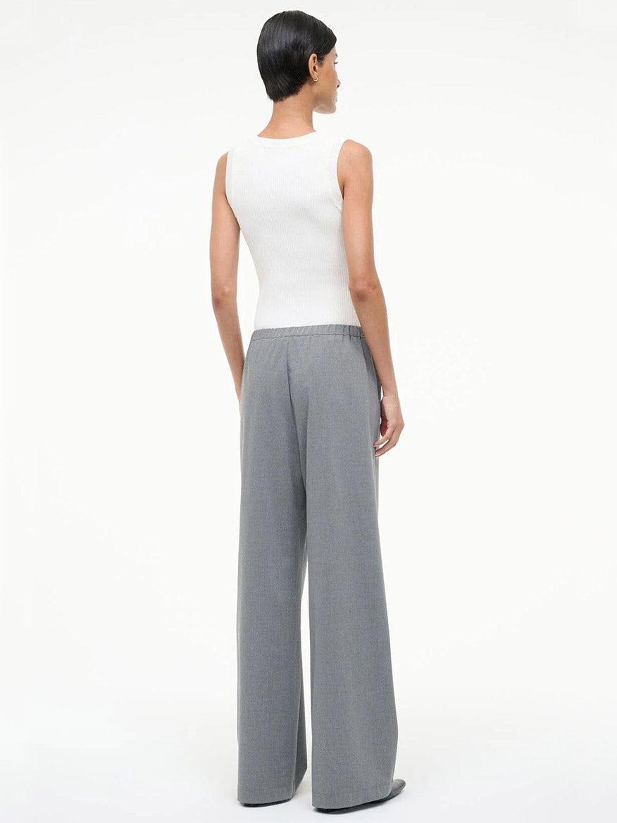 A person stands facing away, wearing a sleeveless white top and the STAUD Denali Pant in Static, a loose-fitting pull-on style, against a plain white background.