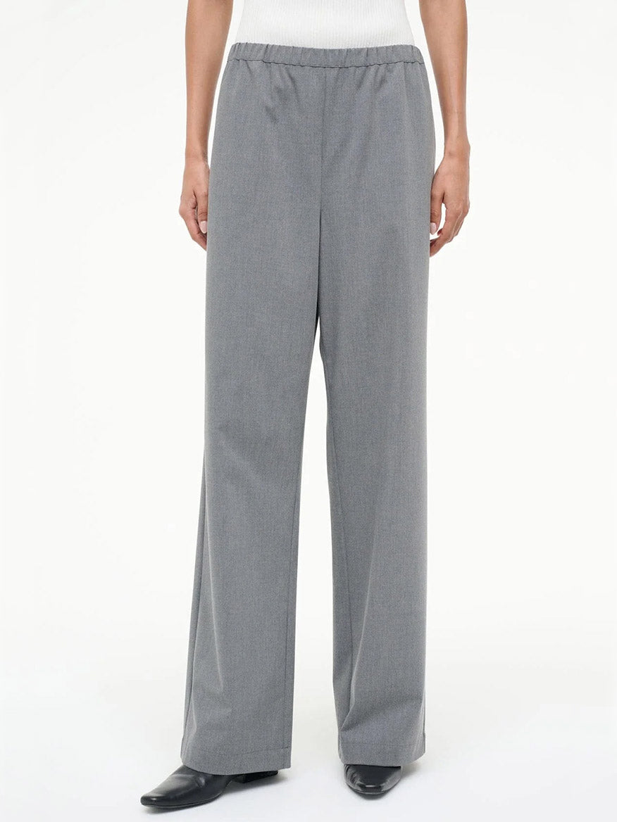 Person wearing the STAUD Denali Pant in Static, a gray, loose-fitting, straight-leg pull-on style with an elastic waistband, paired with black shoes and a white top.
