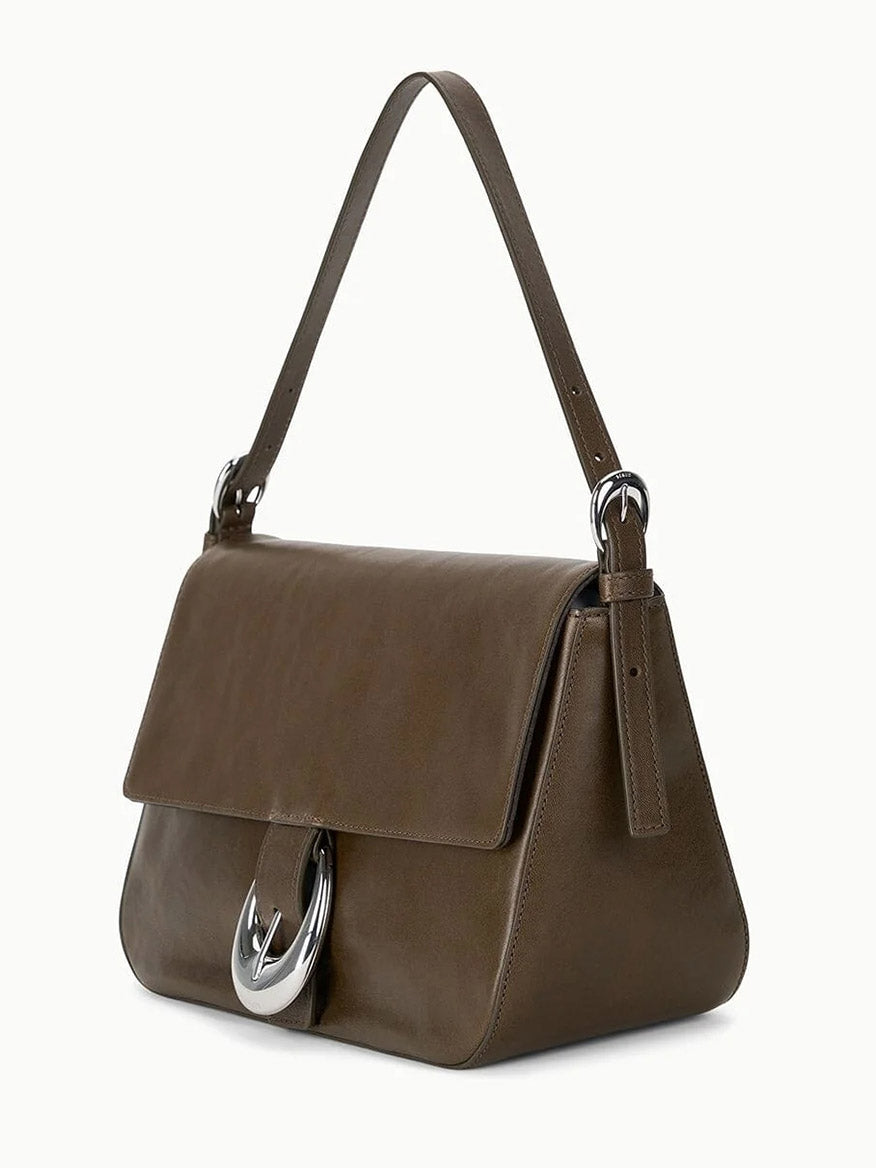 The STAUD Harlow Medium Bag in Truffle, a brown leather shoulder bag with a top handle, silver moon buckle clasp, and rectangular flap design, is shown against a white background.