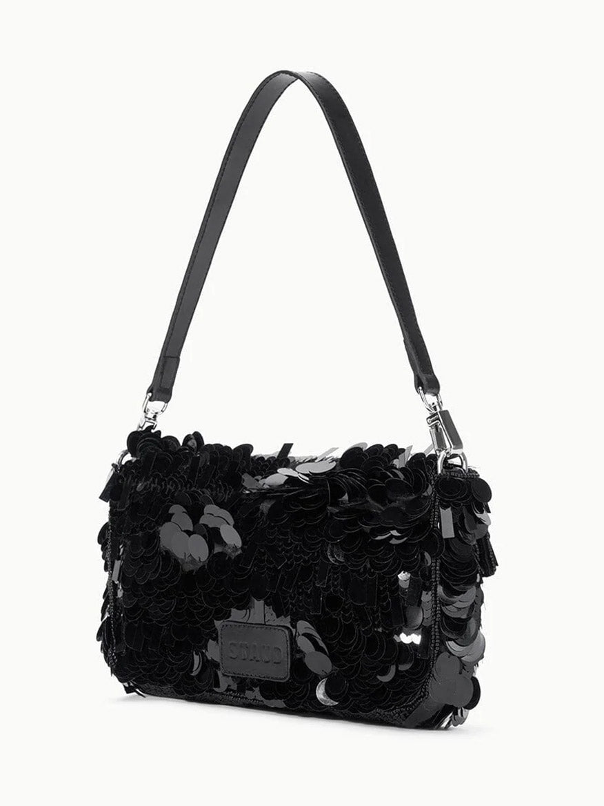 The STAUD Timmy Shoulder Bag in Black features a sleek design with a leather strap and a body embellished with large, shiny black sequins.
