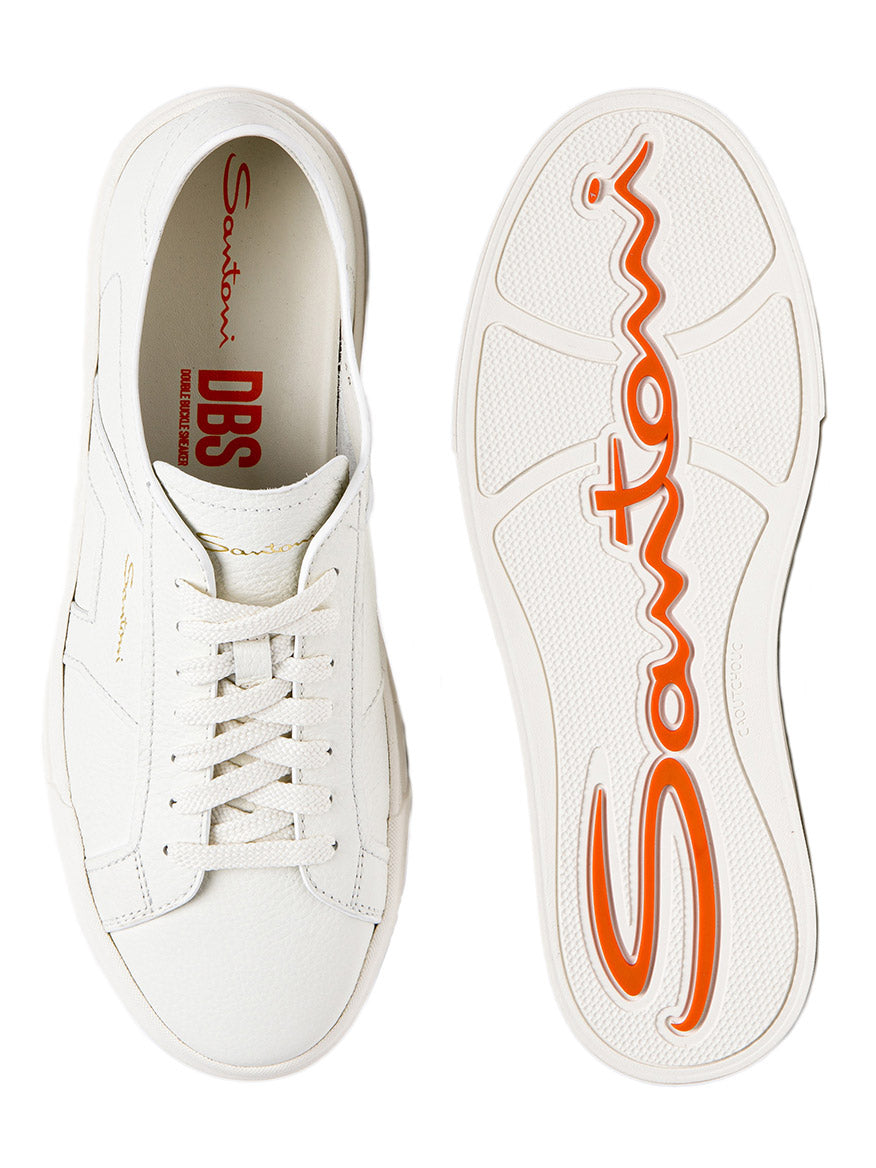 A pair of premium-quality leather Santoni Double Buckle sneakers in White with orange accents on the sole, displayed top-down showcasing both the interior and sole design.