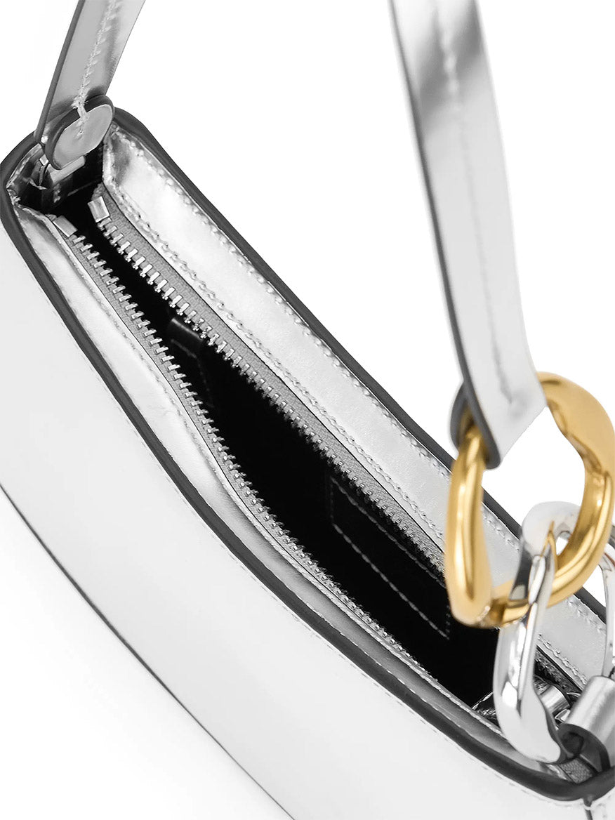 Close-up of the STAUD Ollie Bag in Chrome—a metallic silver mini shoulder bag featuring a zippered opening, black interior, and mixed gold and silver chain handle detail.