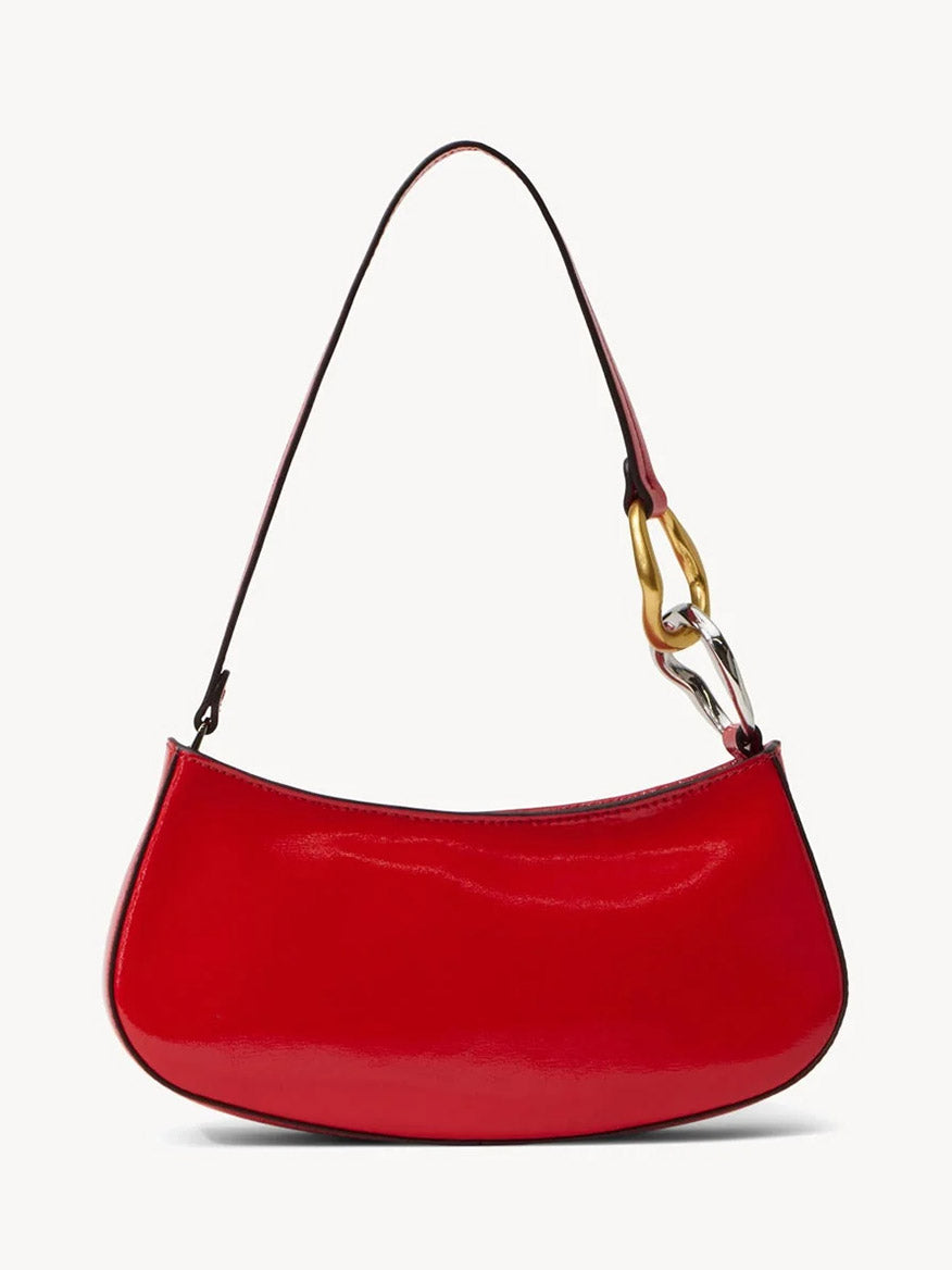The STAUD Ollie Bag in Cherry is a red polished leather mini shoulder bag with a curved shape and a single strap featuring gold and silver chain links on one side.