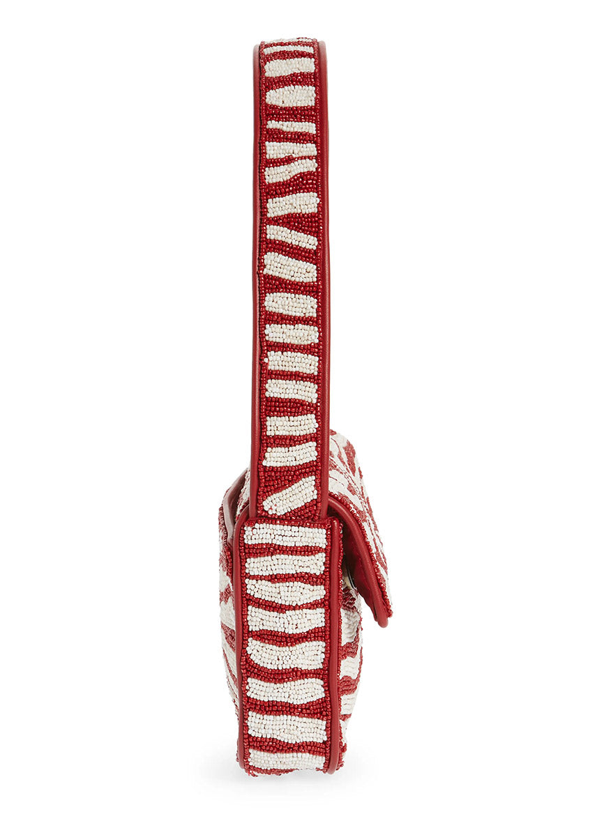Side view of the STAUD Tommy Beaded Bag in Scarlet/White Zebra, featuring a hand-beaded red and white zebra pattern, wide strap, and crafted from vegan leather.