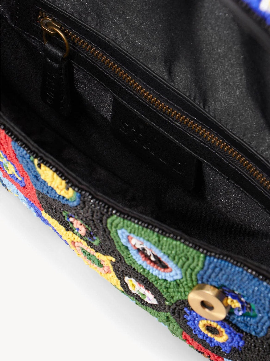Close-up of the STAUD Tommy Beaded Bag in Black Millefiori, featuring a vibrant multicolor beaded flap, zippered pocket, magnetic snap closure, and black fabric interior—a bold shoulder bag to elevate any outfit.