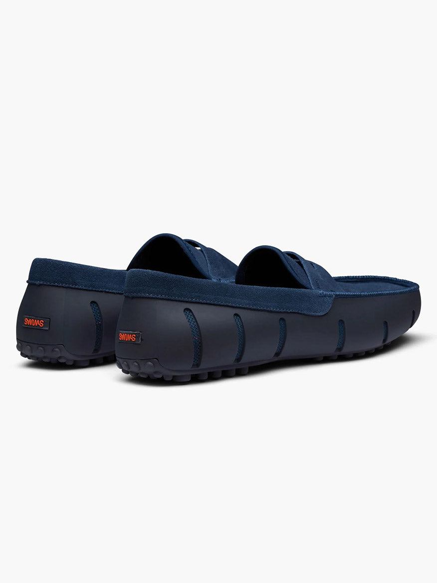 The Swims Lux Driver in Midnight Navy, featuring textured rubber soles and an algae-based footbed, is shown from the back and side against a white background.