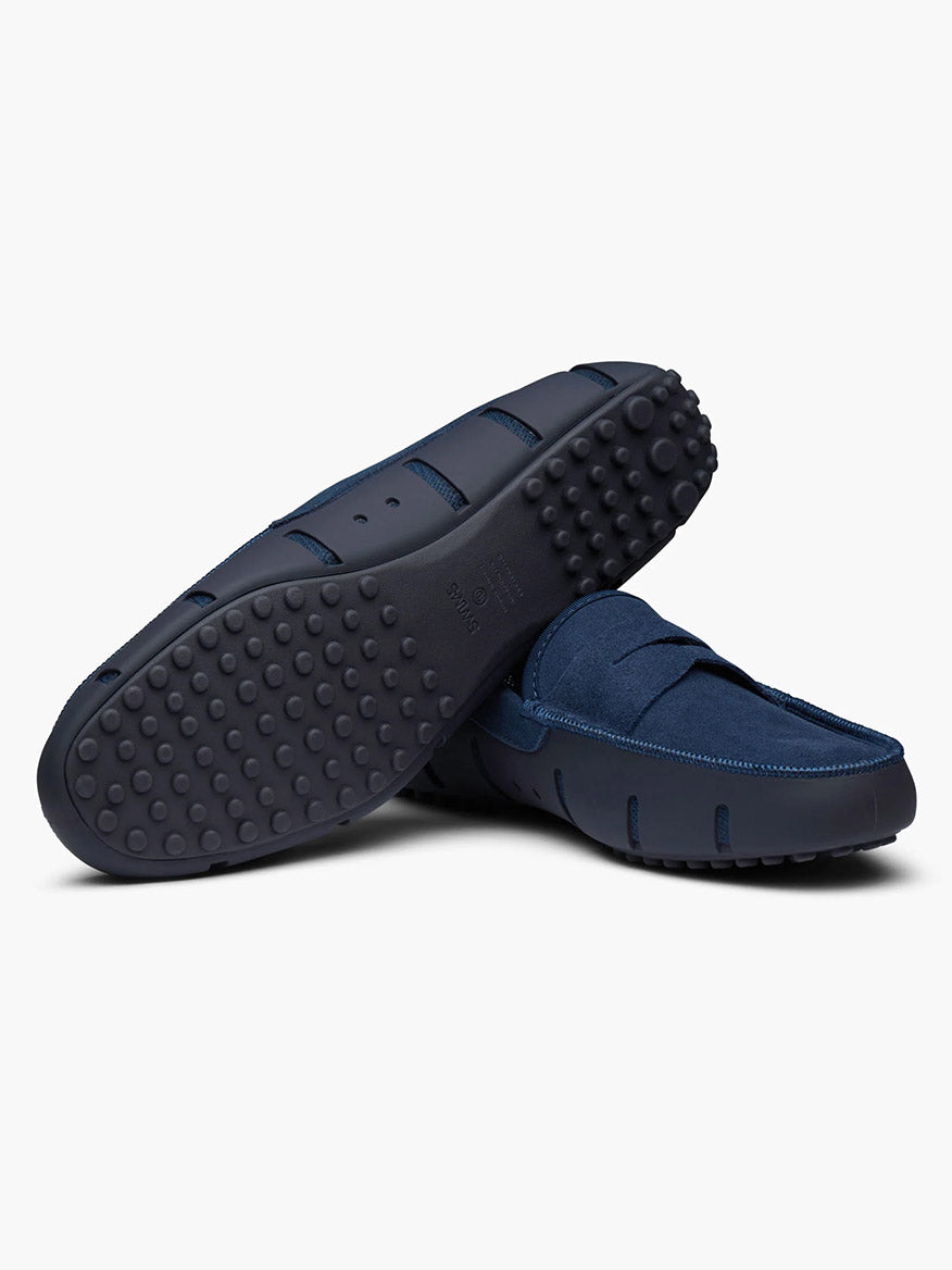 The Swims Lux Driver in Midnight Navy features textured rubber soles and a comfortable algae-based footbed, shown here with one shoe on its side to highlight the bottom tread pattern.