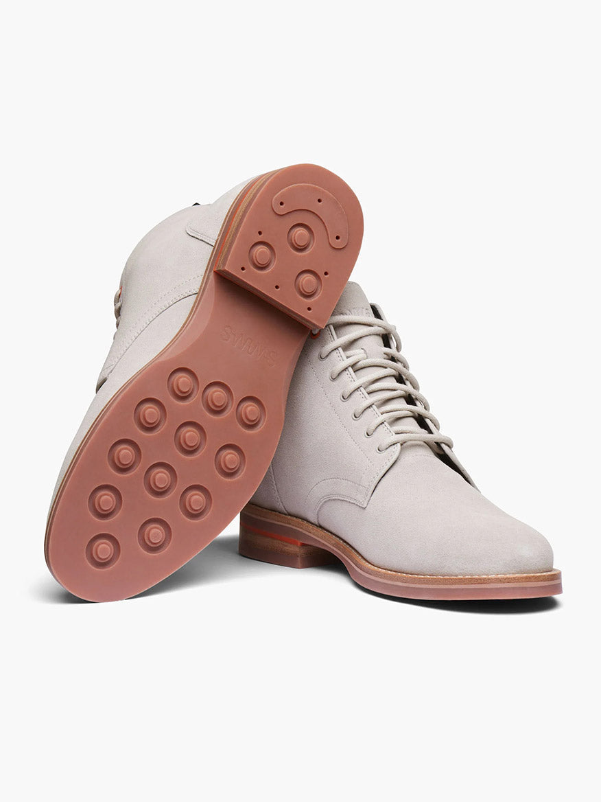 The Swims Oslo Boot in Mist is a light gray lace-up dress shoe made from fine Italian leather, featuring brown outsoles and Bloom algae insoles for comfort, displayed from the side and bottom.