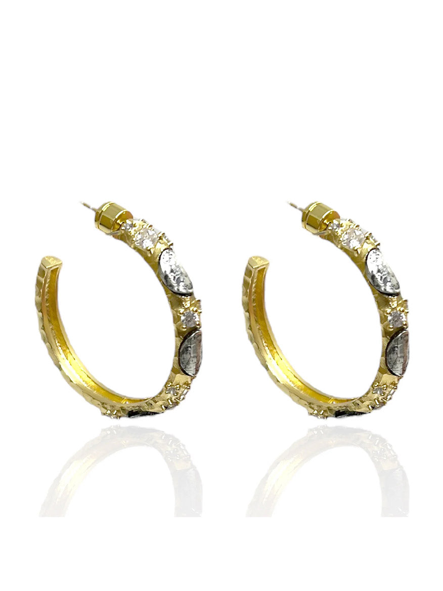 The Tat2 Designs Alma Hoops 1.5" in Gold & Vintage Silver showcase oval and round clear gemstones and custom metal textures, part of the Prince Collection, displayed against a white background.
