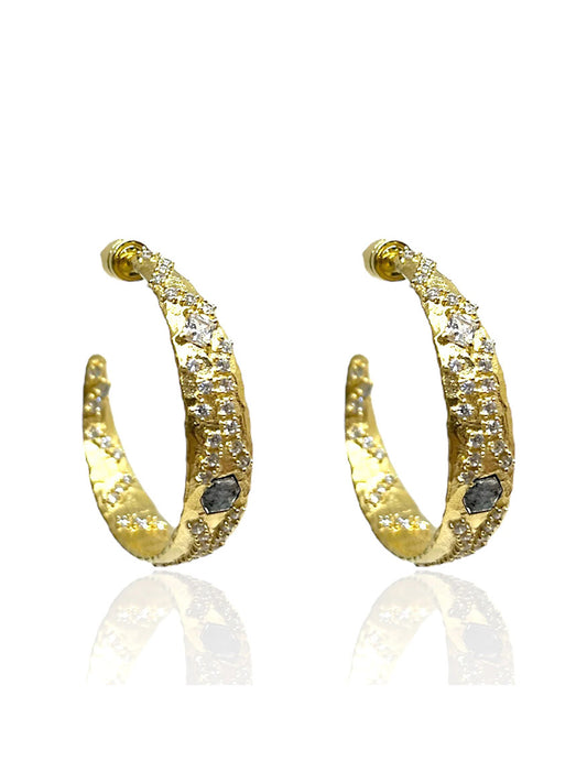 Tat2 Designs Cosa Hoops in Gold & Vintage Silver feature unique finishes and embedded clear gemstones, showcased against a white background with a subtle reflection.
