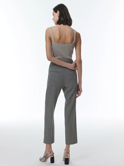 A woman viewed from behind, wearing THEO The Label Eris Baby Houndstooth Pant in Black/Ivory, standing against a plain background.