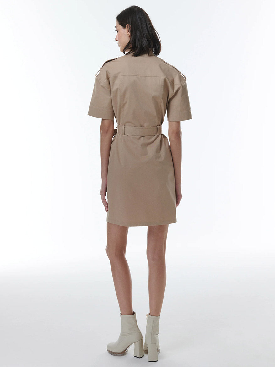 A woman wearing a THEO The Label Thallo Safari Dress in Sand and white ankle boots, viewed from the back.