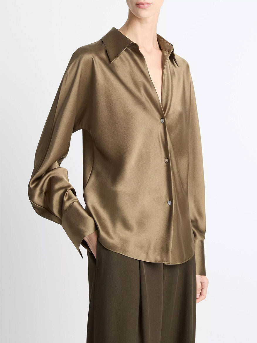 A person wears the Vince Silk Bias Long-Sleeve Blouse in Cypress, featuring a collar and long sleeves, paired with matching wide-leg pants, standing against a plain background.
