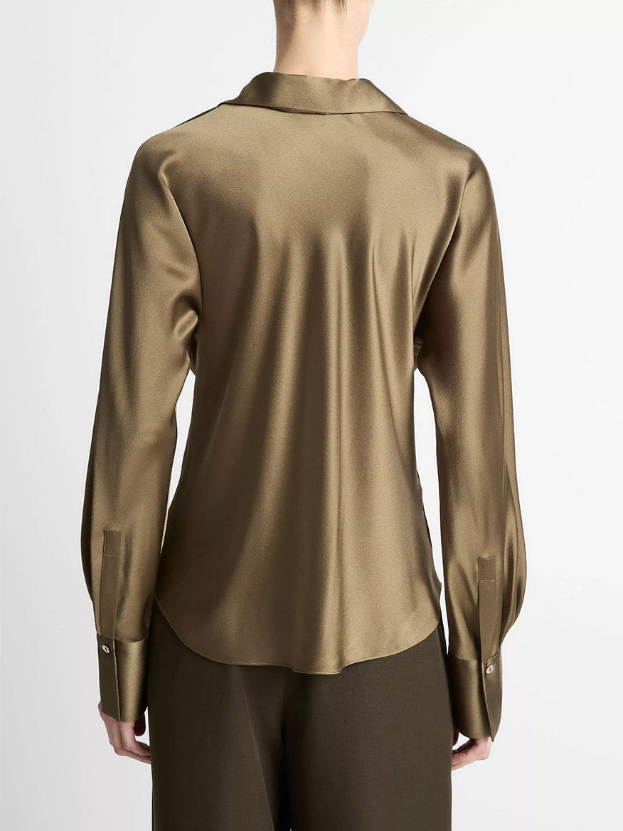 A person is seen from behind wearing the Vince Silk Bias Long-Sleeve Blouse in Cypress, featuring a collar and buttoned cuffs, paired with matching trousers against a plain background.