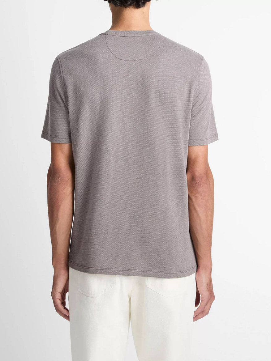 A person is shown from the back against a plain white background wearing the Vince Birdseye Jacquard Pima Cotton T-Shirt in Smoke with white pants.