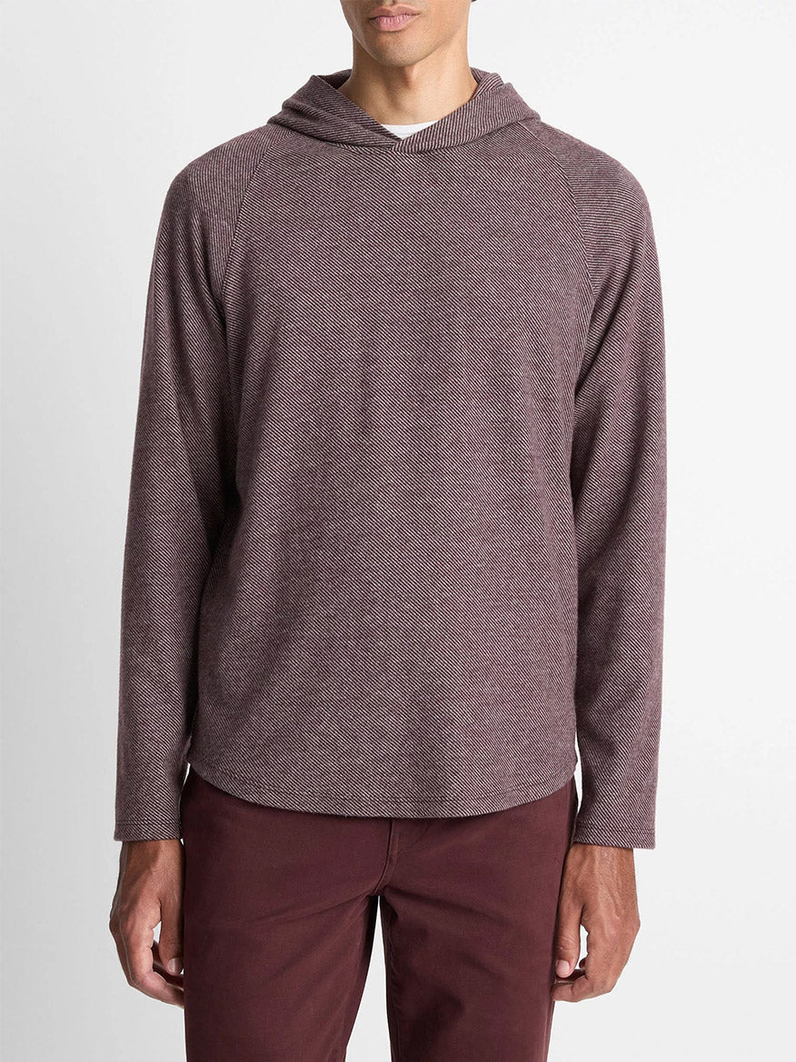 A man wears the Vince Broken Twill Pullover Hoodie in Port/Heather Grey, made from a soft modal-cotton blend, paired with matching maroon pants, standing against a plain white background.