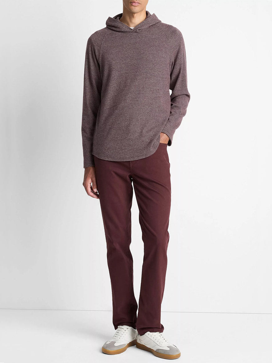 A person stands against a plain white background wearing the Vince Broken Twill Pullover Hoodie in Port/Heather Grey, matching maroon pants, and white sneakers with tan soles.