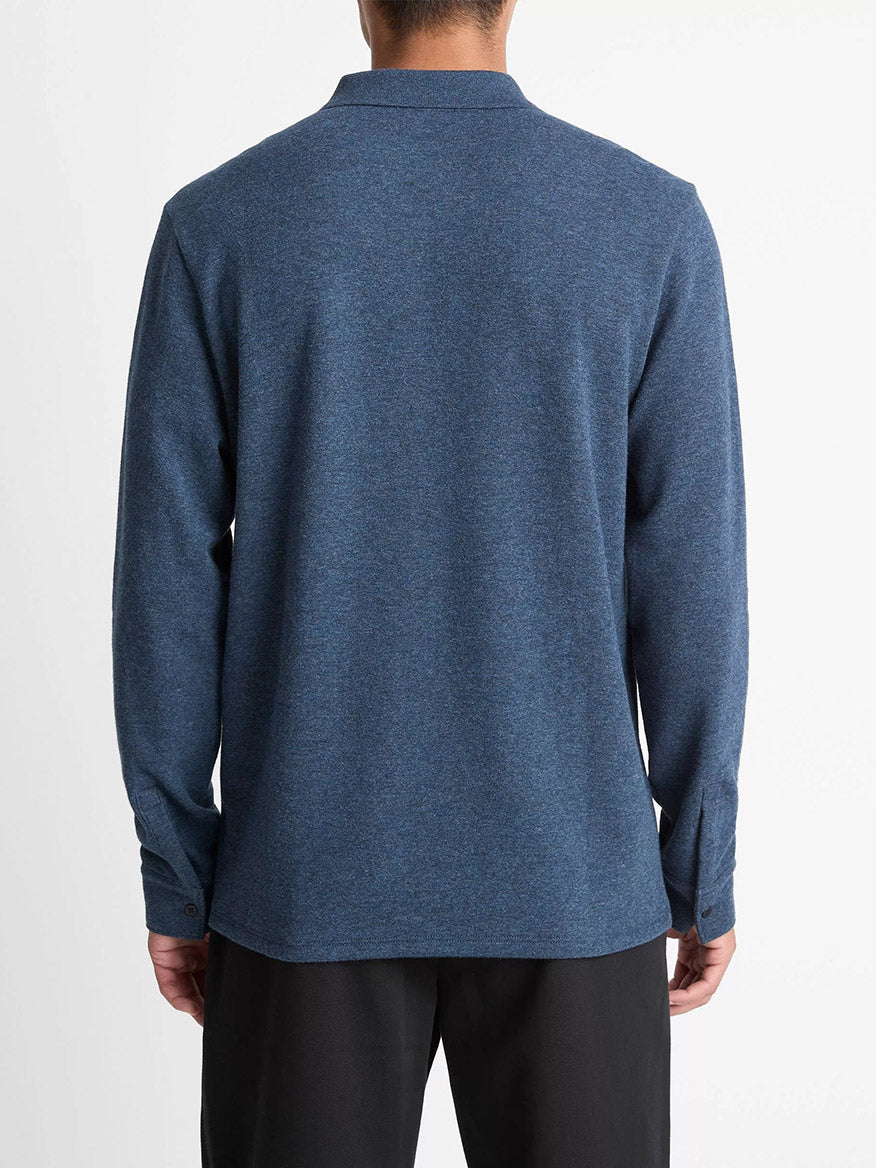 A person is shown from the back wearing the Vince Heathered Double-Face Cotton-Blend Polo Shirt in Heather Coastal Blue/Heather Fog and black pants against a plain white background.