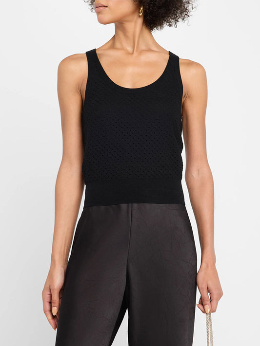 Person wearing the Vince Italian Cotton-Blend Mesh Double-Layer Tank in Black, a sleeveless scoop-neck design with subtle mesh detail, paired with high-waisted dark pants and standing against a plain background.