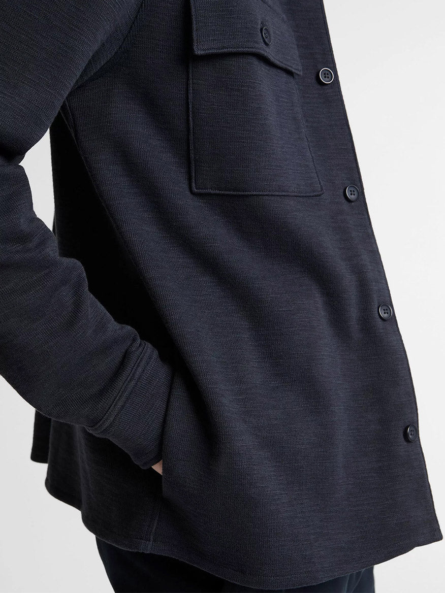 A person wearing the Vince Double-Slub Cotton-Blend Shirt Jacket in Coastal Blue, featuring textured cotton-blend fabric and a chest pocket, with one hand in their pocket.