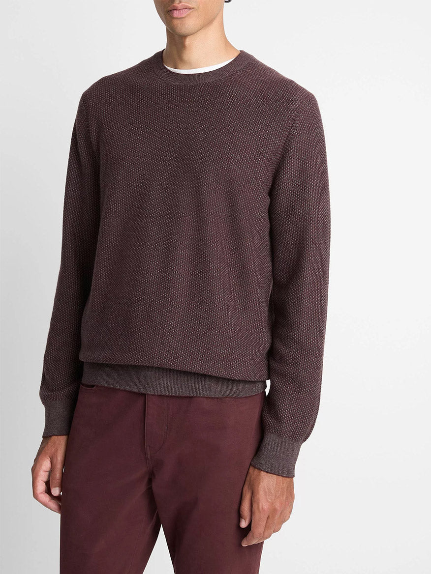 A man wears the Vince Geo-Jacquard Wool-Blend Crew Neck Sweater in Port/Medium Heather Grey over a white undershirt with matching maroon pants, standing against a plain white background.