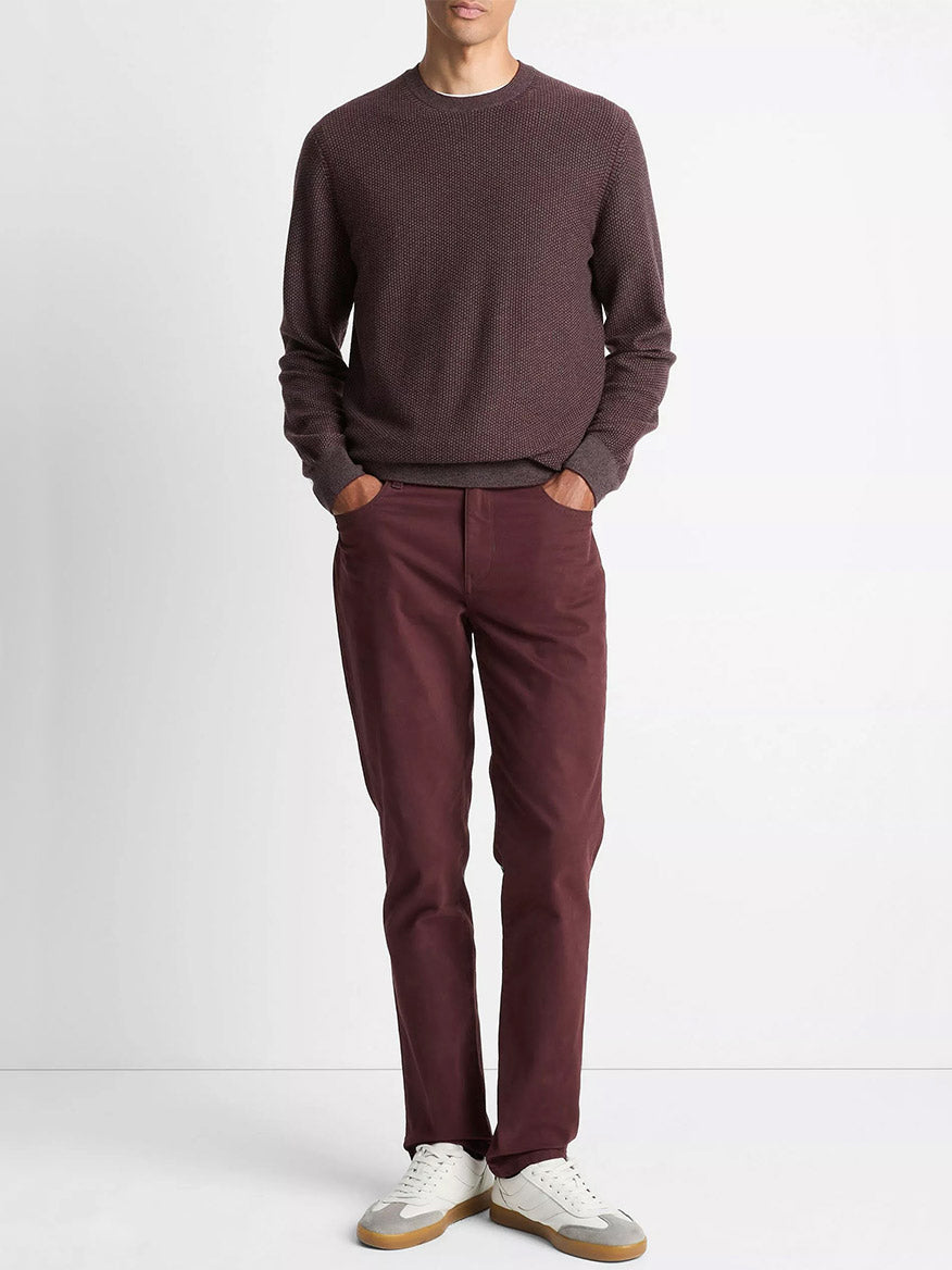 A person stands against a plain background wearing a Vince Geo-Jacquard Wool-Blend Crew Neck Sweater in Port/Medium Heather Grey, matching maroon pants, and white sneakers.