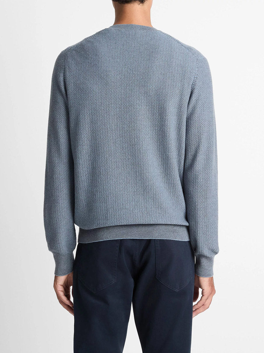 A person is seen from the back wearing the Vince Geo-Jacquard Wool-Blend Crew Neck Sweater in Parlor Blue/Medium Heather Grey with dark blue pants, set against a plain white background.
