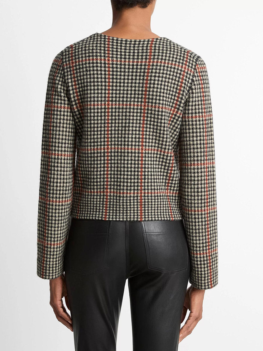 Model wearing the Vince Glen Plaid Wool-Cashmere Cardigan Jacket in Cobblestone/Black Combo with black leather pants, shown from the back against a white background.