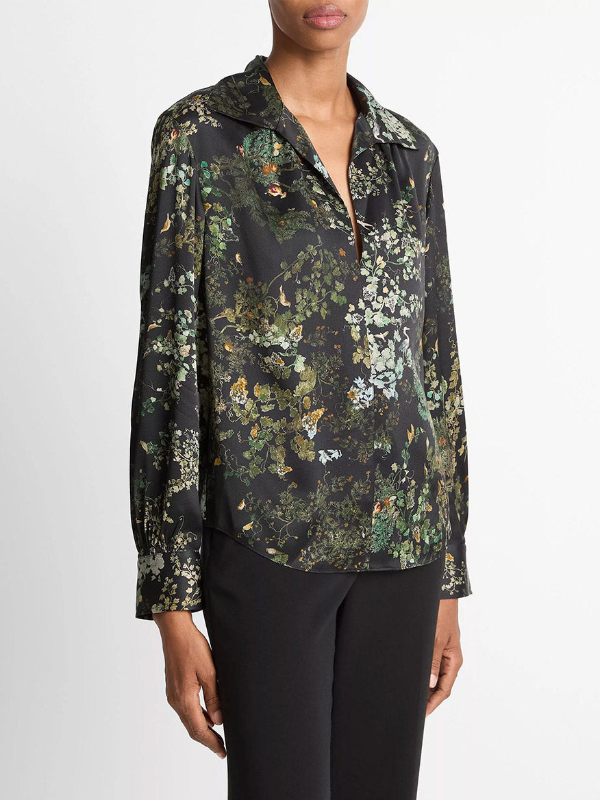 Model wears the Vince Smocked Grape Vine Silk Long-Sleeve Blouse in Black Sky, paired with black pants, standing against a white background.