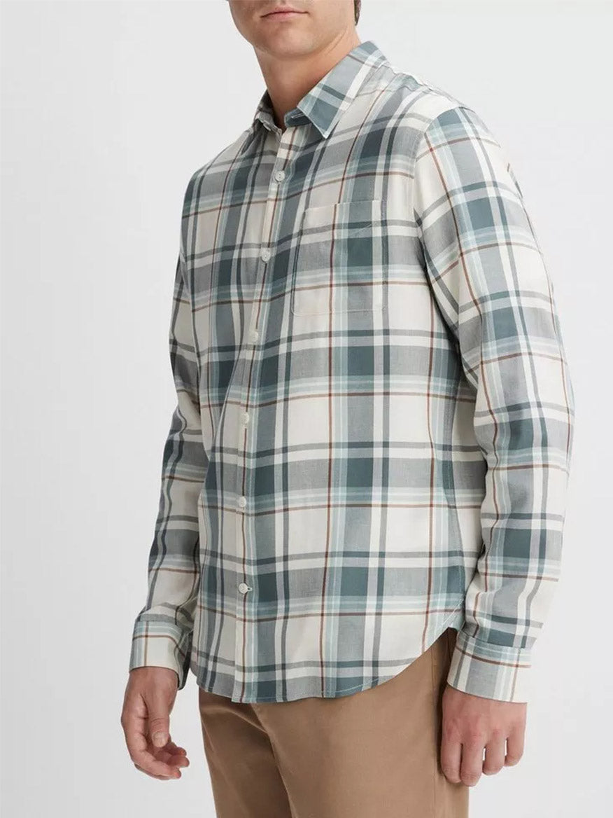 A person wearing a Vince Manchester Plaid Shirt in Bone/Dusty Teal with beige trousers stands against a plain background.