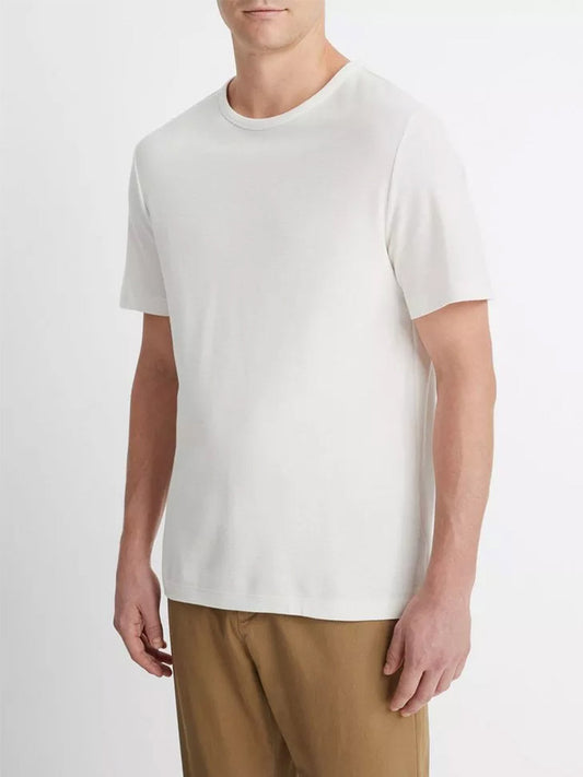 Man wearing a Vince Pima Cotton Piqué Crew Neck T-Shirt in Alabaster and khaki pants.
