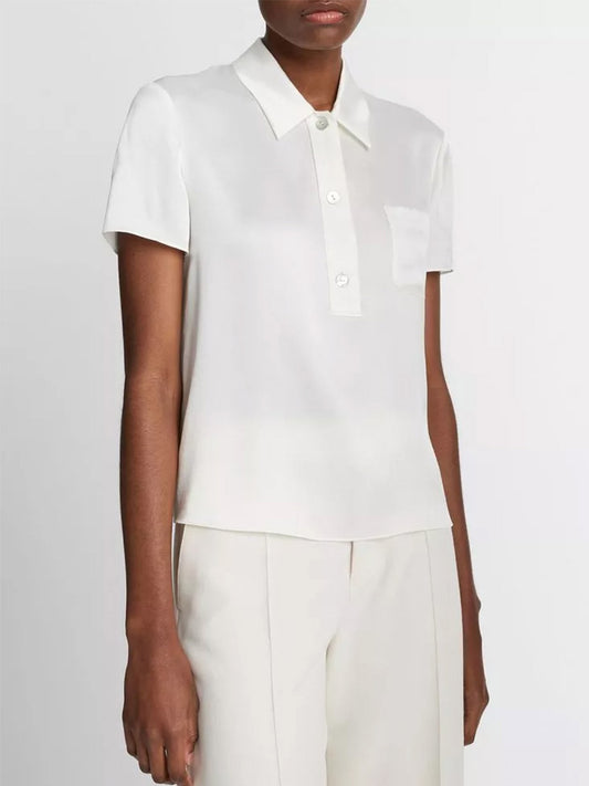 Woman wearing a Vince Silk Short-Sleeve Polo Shirt in Off-White with button-front closure and white trousers.