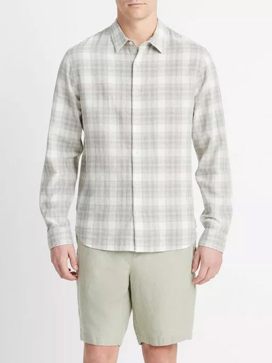 Sentence with Product Name: Man wearing a Vince Salton Plaid Long-Sleeve Shirt in Alabaster/Dried Cactus and khaki shorts standing against a neutral background.