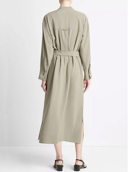 A person wearing a Vince Soft Utility Shirt Dress in Sea Fern made from responsible materials from the back view, paired with black open-toe heels.